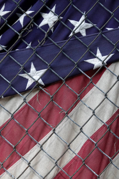 istock USA Flag behind a fence 1184514221
