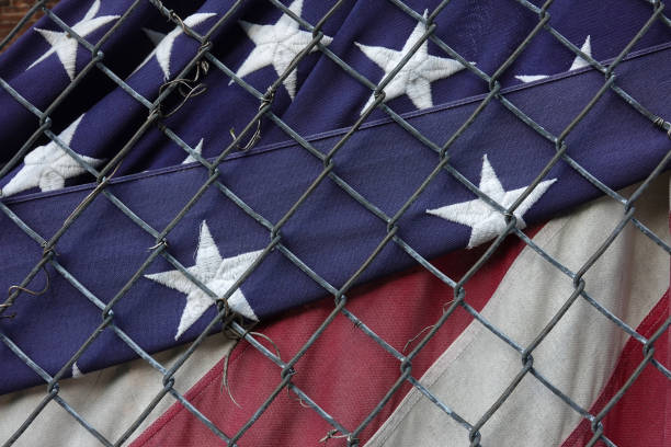 istock USA Flag behind a fence 1184514247