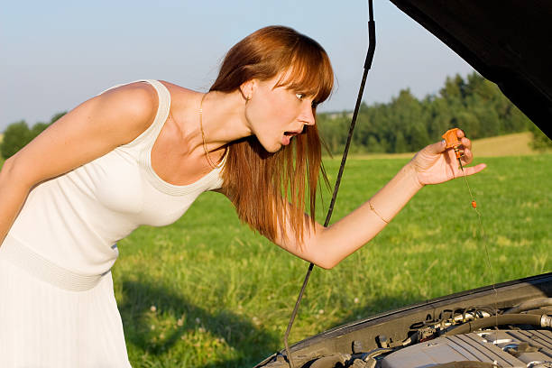 istock young woman bent over car engine 118451453