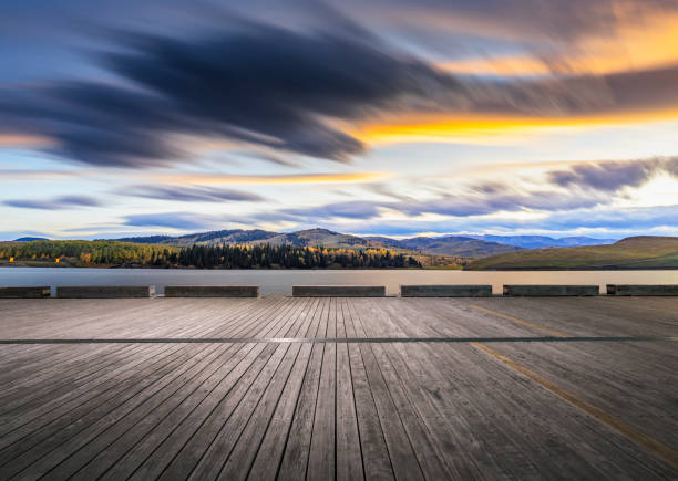 istock Empty wooden deck front of lake and mountains at sunset 1184522509