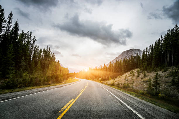 istock Clouds over a winding two-lane highway towards Rocky Mountains 1184522738