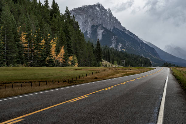istock Clouds over a winding two-lane highway towards Rocky Mountains 1184522815