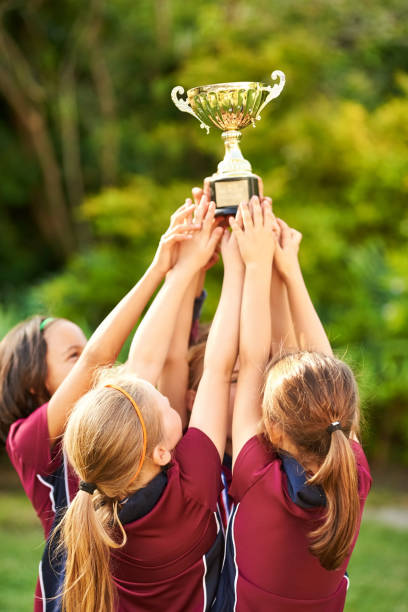 istock Soccer champs hold trophy up high 1184525359