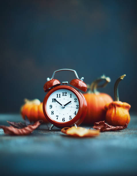 istock Time for Fall. Red alarm clock with leaves and pumpkins 1184527848