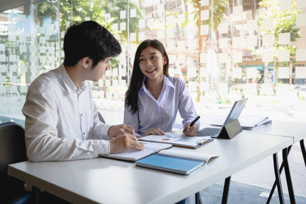 istock Young modern businessman and woman working together in modern co-work space. Creative concept. 1184534529