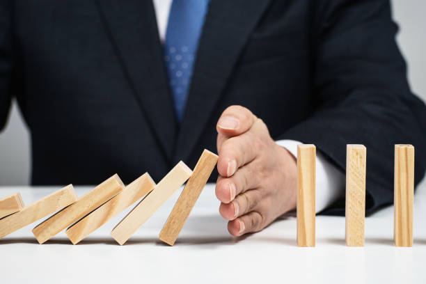 istock Male hand stopping the domino effect. Risk control concept. 1184534684