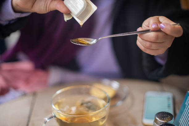 istock Woman pouring honey onto spoon 1184542290