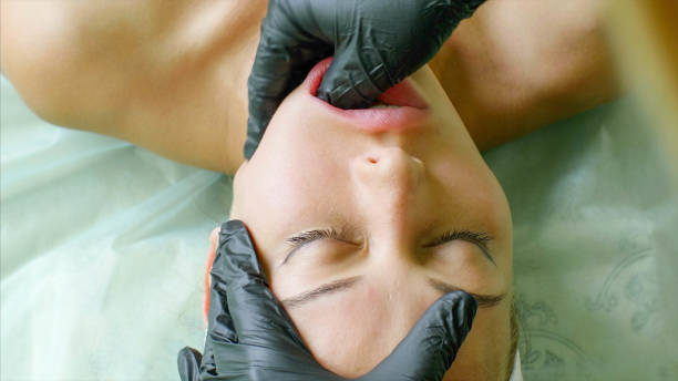 Physiotherapist is making facial massage working on woman's jaw in beauty clinic stock photo