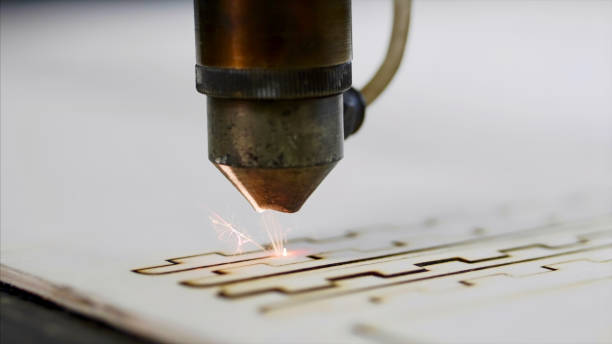 industrial laser is cutting a pattern on a plywood sheet - cnc laser cutting imagens e fotografias de stock