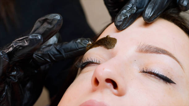 istock The master is adding a brown pigment on the client's eyebrow. 1184545860