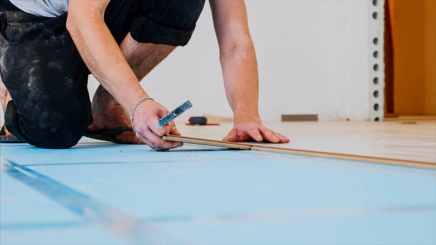 istock A worker is fitting laminate with piece of panel and a small hammer in the room. 1184545877