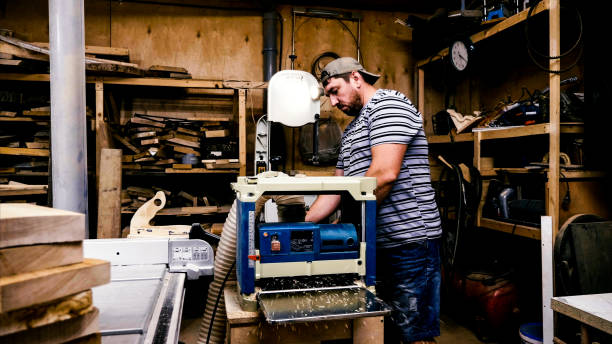 istock Male carpenter is working with cabinet planer machine at wood workshop 1184545913