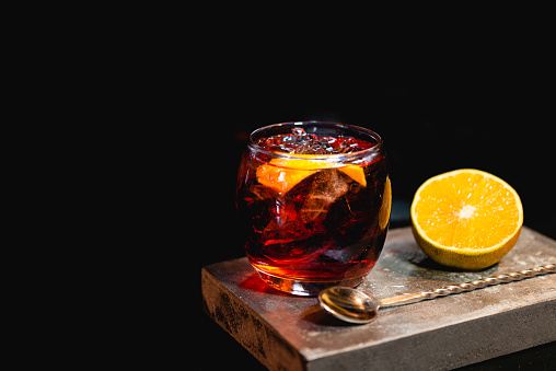 Boulevardier cocktail on stone background in gray color.