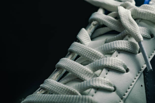 istock Beautiful white shoeloces  on a dark background texture. 1184548945