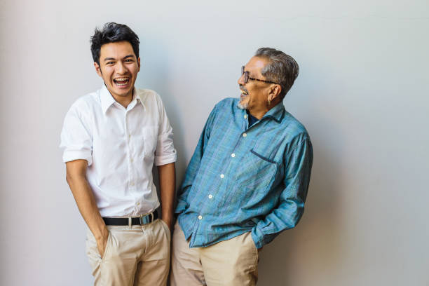 retrato de padre mayor asiático y su hijo adulto divirtiéndose juntos y de pie sobre fondos grises - grandparent adult smiling looking at camera fotografías e imágenes de stock