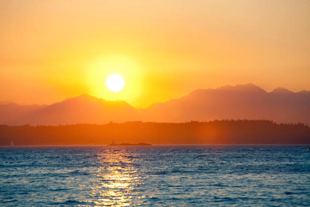 istock Orange sunset behind mountains with lake in foreground 1184555253