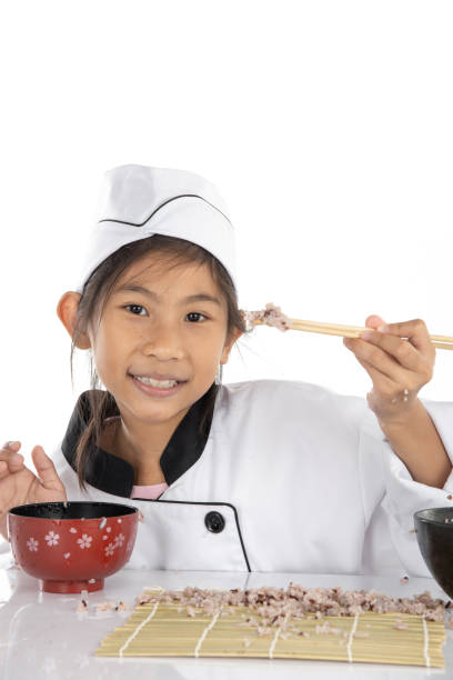 istock Asian girl learning how to making sushi on white background 1184561268