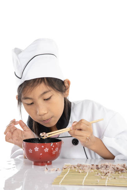 istock Asian girl learning how to making sushi on white background 1184561496