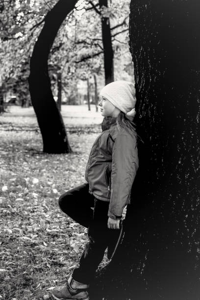 istock Girl is worth relying its back on tree 1184563450