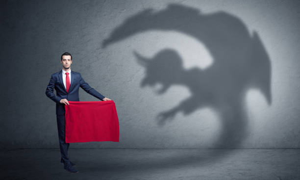 istock Businessman with imp shadow and toreador concept 1184563545
