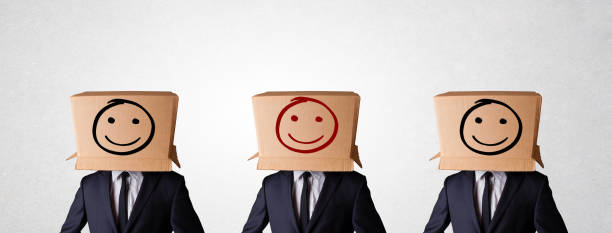istock Handsome men in suit gesturing with drawn smiley faces on box 1184567389