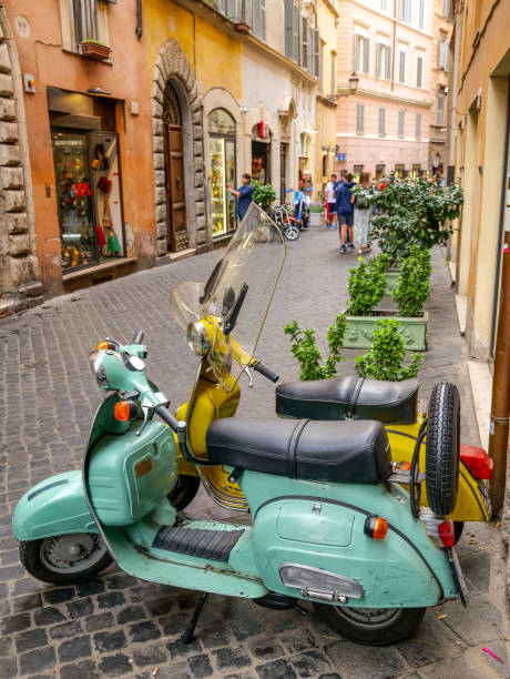 two vintage vespa scooters parked along a stone alley near piazza navona in the historic heart of rome - vespa scooter imagens e fotografias de stock