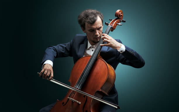 cellist playing on instrument with empathy - soloist imagens e fotografias de stock