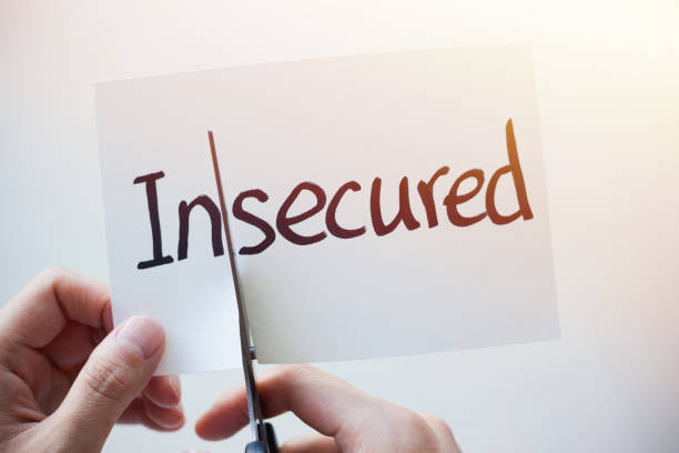 istock Cutting Out the Word Insecured and Secured on Paper with Scissors 1184573089