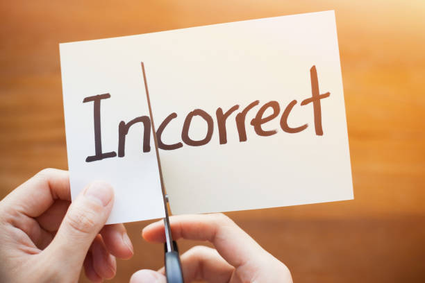 istock Cutting Out the Word Incorrect and Correct on Paper with Scissors 1184573245