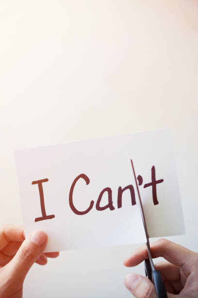 istock Cutting Out the Word I Can't and Can on Paper with Scissors 1184573405