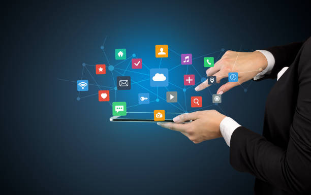 istock Hand holding tablet and application icons above 1184574471