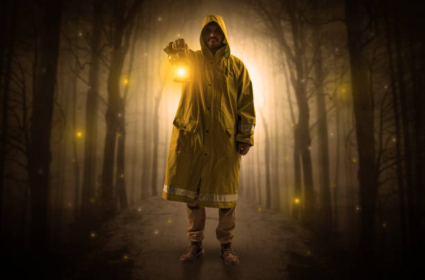 istock Mysterious man coming from a path in the forest with glowing lantern concept 1184575544