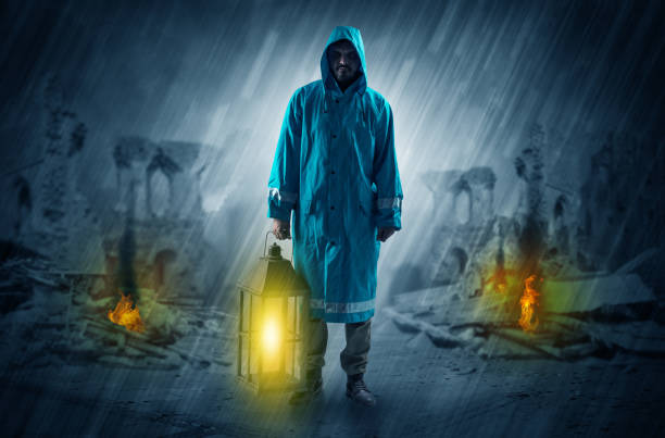 istock Man with a glowing lantern at a catastrophe scene 1184575635