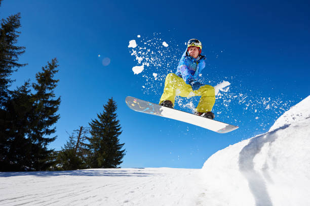 istock Snowboarding closeup in jump on blue sky background 1184575781
