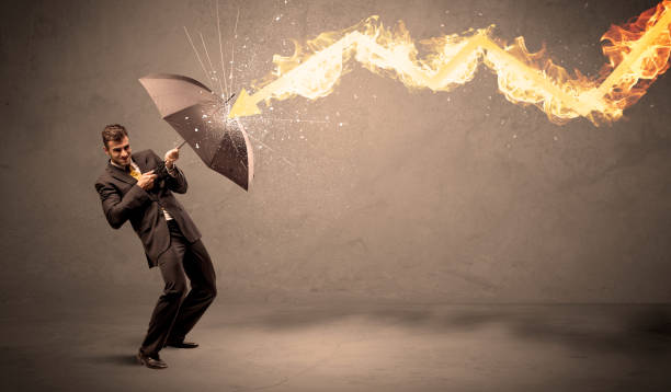 istock Business man defending himself from a fire arrow with an umbrella 1184578621
