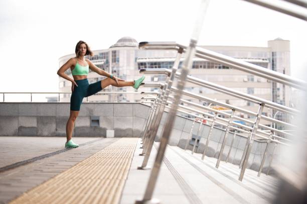 istock woman runner stretching leg muscle before running outdoors for athlete training. 1184580857