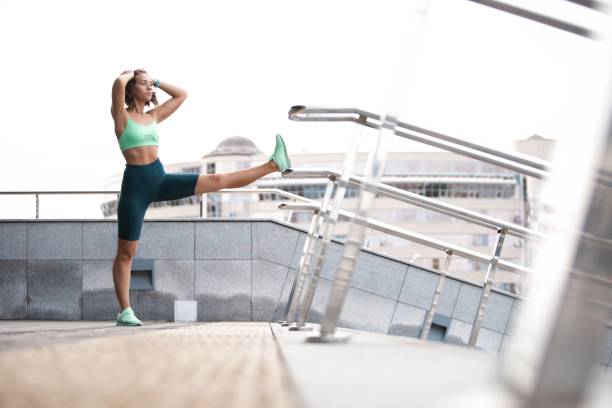 istock woman runner stretching leg muscle before running outdoors for athlete training. 1184580866