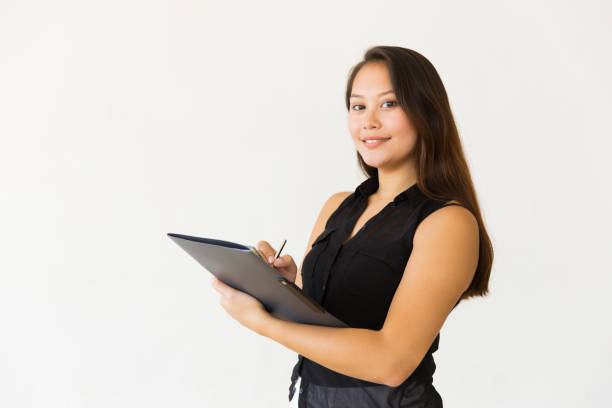 istock Attractive young woman writing in folder 1184581305