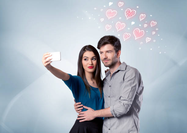 istock Couple in love taking selfie with red heart 1184582308