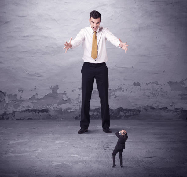 istock Angry big manager looking at small business man 1184583425