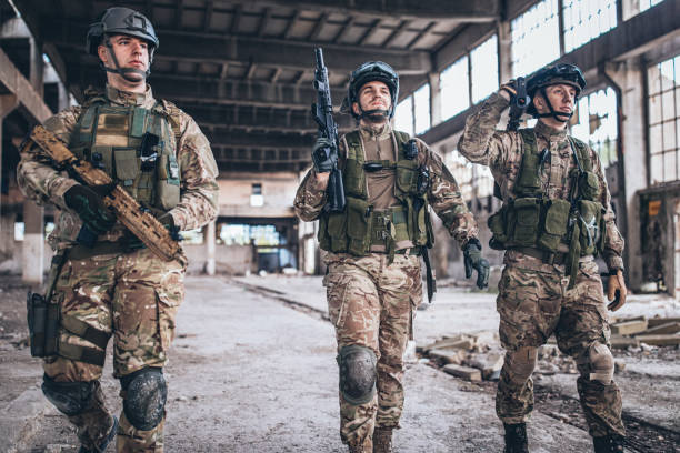 istock Three soldiers walking in abandoned warehouse 1184583448