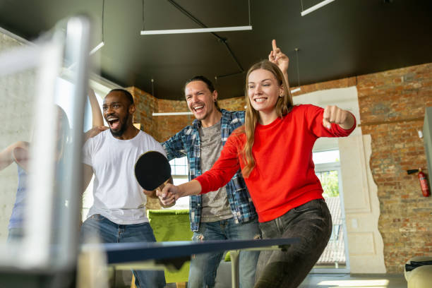 istock Young people playing table tennis in workplace, having fun 1184584230