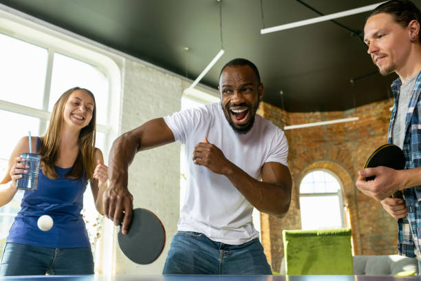 istock Young people playing table tennis in workplace, having fun 1184584257