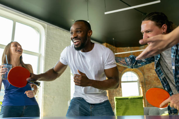 istock Young people playing table tennis in workplace, having fun 1184584262