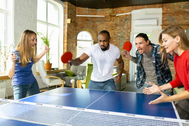 istock Young people playing table tennis in workplace, having fun 1184584281
