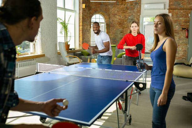 istock Young people playing table tennis in workplace, having fun 1184584288