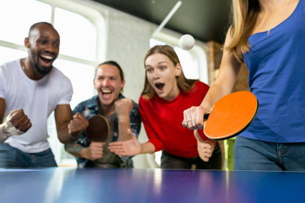 istock Young people playing table tennis in workplace, having fun 1184584329
