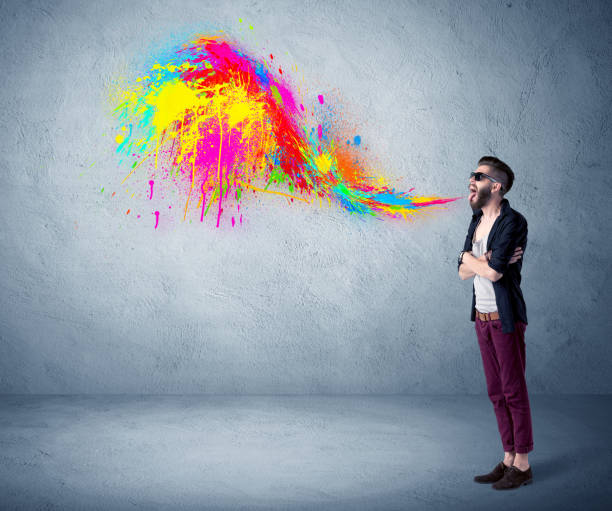 istock Hipster guy shouting colorful paint on wall 1184585186