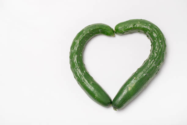 Two heart-shaped cucumbers on white background