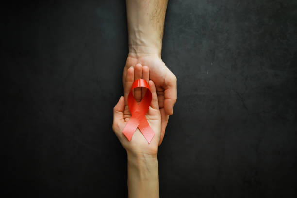 symbol ludzkiej choroby wirusa niedoboru odporności. czerwona wstążka. pomocna dłoń i wsparcie. - immunodeficiency zdjęcia i obrazy z banku zdjęć